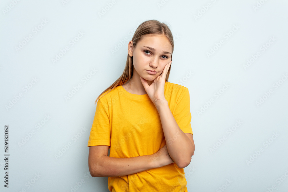 Young caucasian girl isolated on blue background who is bored, fatigued and need a relax day. Young caucasian girl isolated on blue background who is bored, fatigued and need a relax day.