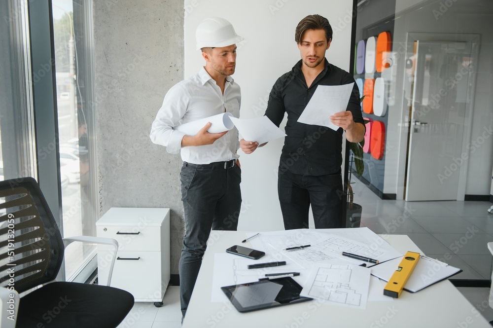 © Serhii - Engineer or architect teamwork working on construction project with building model and blueprint in office. Construction concept. © Serhii - Engineer or architect teamwork working on construction project with building model and blueprint in office. Construction concept.