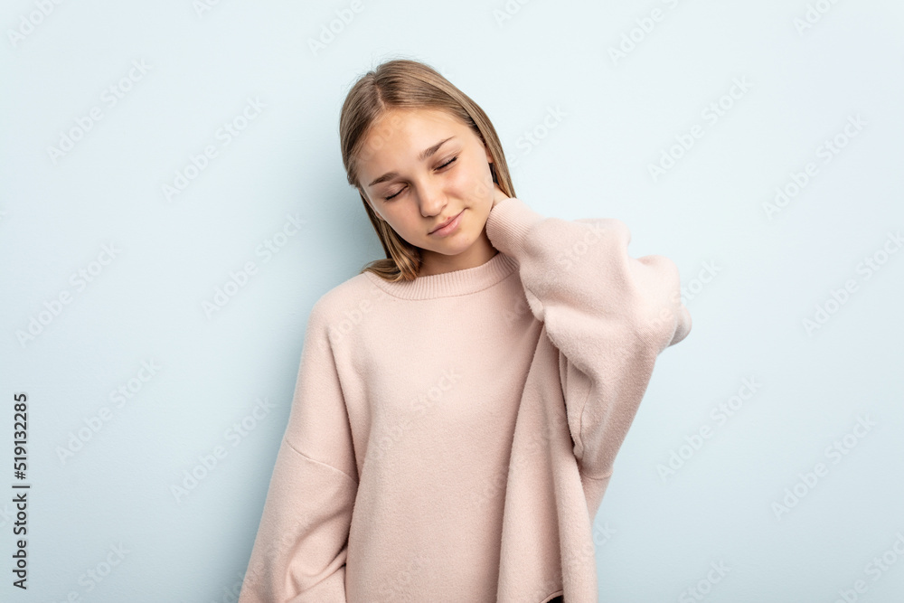 Young caucasian girl isolated on blue background having a neck pain due to stress, massaging and touching it with hand. Young caucasian girl isolated on blue background having a neck pain due to stress, massaging and touching it with hand.
