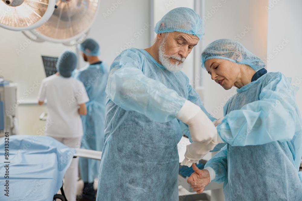 Team of surgeons in the operating room preparing for surgery Team of surgeons in the operating room preparing for surgery