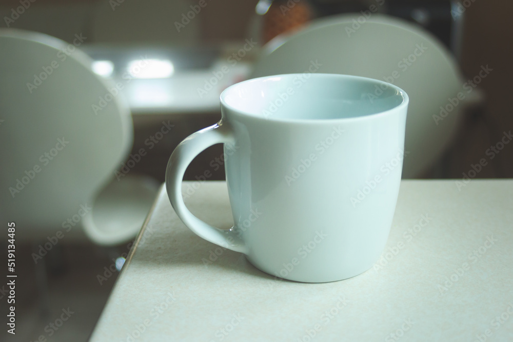 White empty mug standing on the counter White empty mug standing on the counter