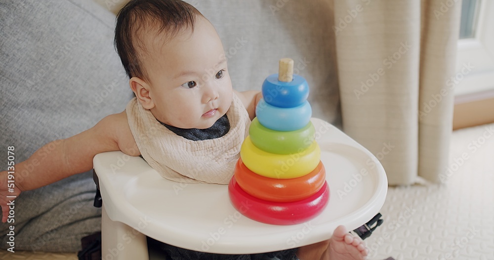 happy Asian baby playing with colorful pyramid toy at home, development of fine motor skills in newborn child. happy family mom and baby play pyramid toy. kindergarten preschool education happy Asian baby playing with colorful pyramid toy at home, development of fine motor skills in newborn child. happy family mom and baby play pyramid toy. kindergarten preschool education