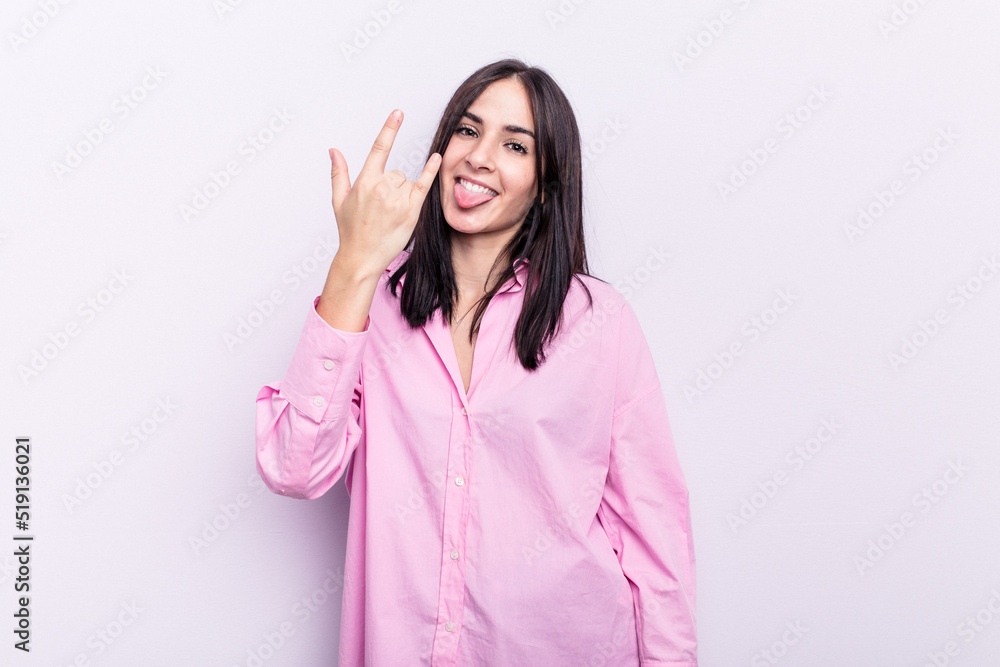 Young caucasian woman isolated on pink background showing rock gesture with fingers Young caucasian woman isolated on pink background showing rock gesture with fingers