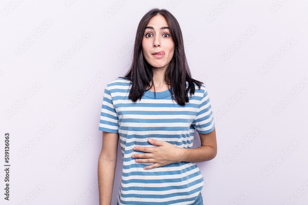 Young caucasian woman isolated on pink background touches tummy, smiles gently, eating and satisfaction concept. Young caucasian woman isolated on pink background touches tummy, smiles gently, eating and satisfaction concept.