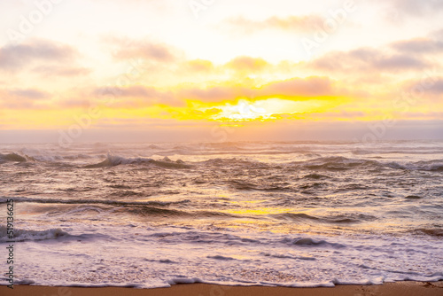 Landscape with sea sunset on beach. Beautiful view on ocean horizon with orange sun and clouds