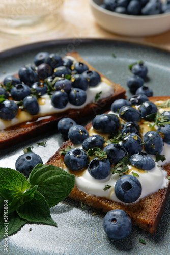 Fruity topped bread with blueberries on Greek yogurt. Healthy toast (tartine). 