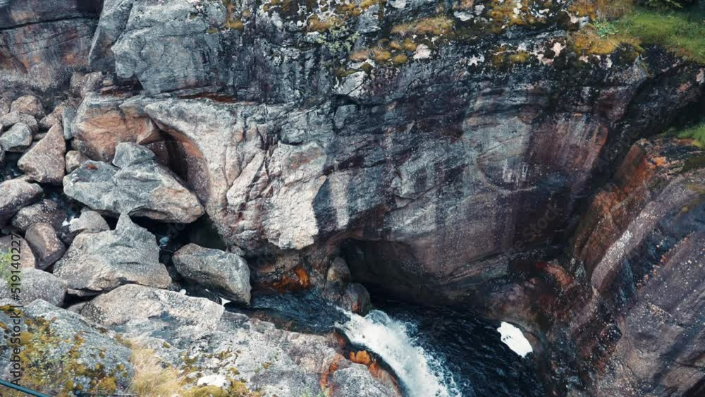 Aerial view of the steep cliffs of the Dorgefossen. The river cascades down the deep canyon. Slow-motion, pan left. Aerial view of the steep cliffs of the Dorgefossen. The river cascades down the deep canyon. Slow-motion, pan left.
