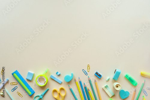 Various school supplies on a light peach background, flat lay. Place for text.