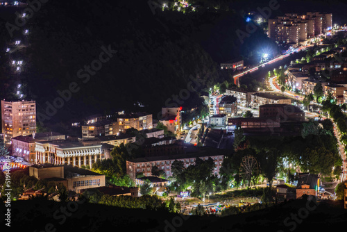 Night city from a bird's eye view. The light of houses and cars. A beautiful city with rivers, bridges and beautiful buildings. City among the mountains, Kapan, Armenia