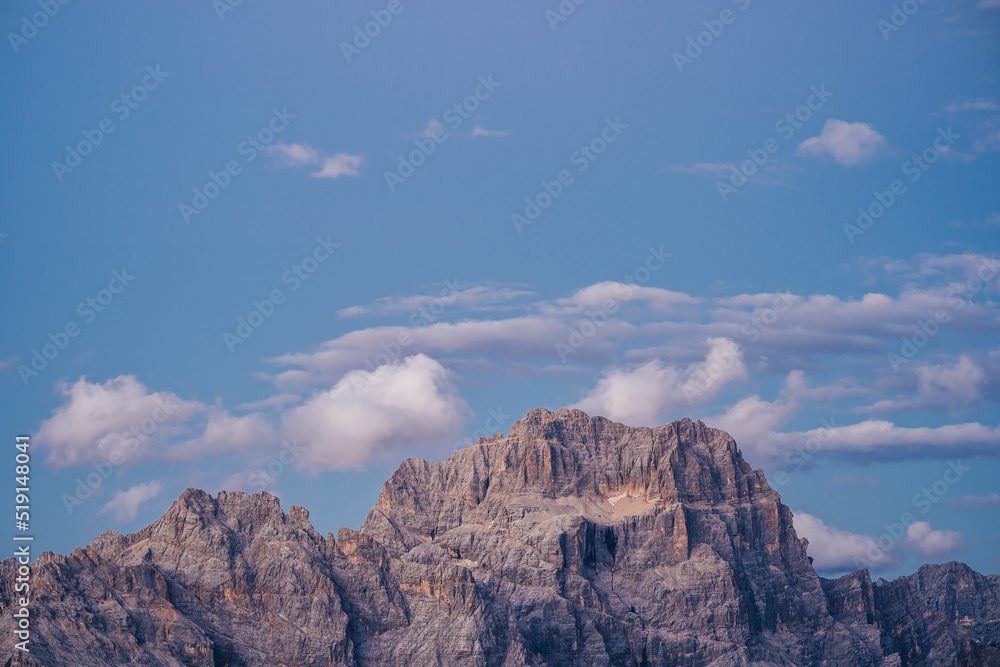 Sunset or sunrise over Punta Sorapiss, Dolomites, Tyrol, Italy. High alpine landscape with huge rock walls. Sunset light over rock face. Sunset or sunrise over Punta Sorapiss, Dolomites, Tyrol, Italy. High alpine landscape with huge rock walls. Sunset light over rock face.