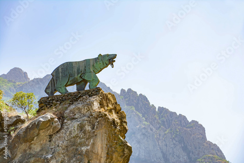 Bear monument in the mountains. Statue of a bear on a rock. Statue and unique mountains. The key of Kajaran is a monument in the city of Kapan  Syunik region of Armenia