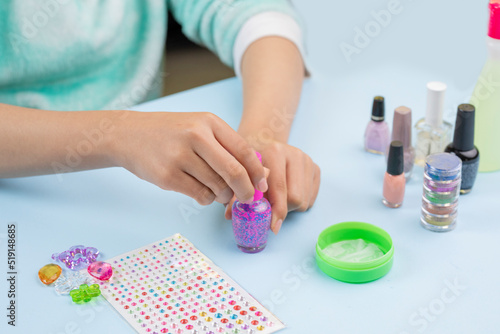 Hands of a young woman with a nail varnish in her hands, to paint her nails at home