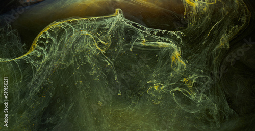 Liquid fluid art abstract background. Black, yellow dancing acrylic paints underwater, space smoke ocean