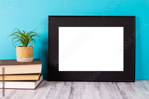 Mock up poster. Minimal template with empty picture frame mock up. Blue background with books