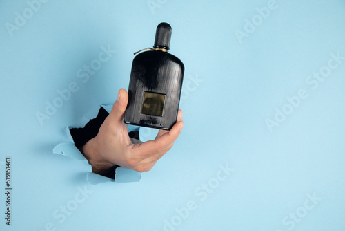 bottle of perfume in a man hand