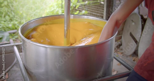 Asian male farmer in rural area use blending machine for separating the pulp of  palmyra palms (lontar, fan palm) to sell for making toddy palm cake(Kanom Tarn). photo