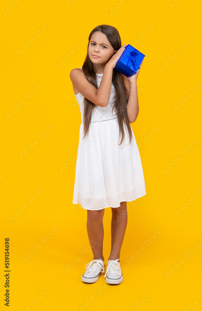 curious teen girl hold present box on yellow background curious teen girl hold present box on yellow background