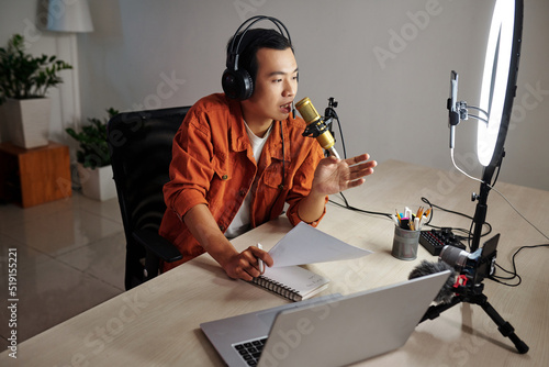 Blogger following scenario when recording podcast for his channel on social media photo