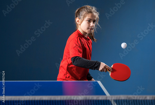  girl child plays ping pong on indoor photo