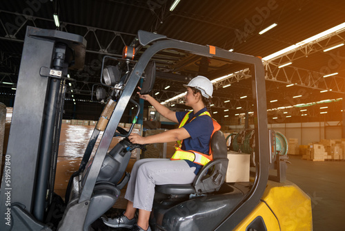 Portrait of woman forklift driver in factory, Woman cargo worker work in warehouse.