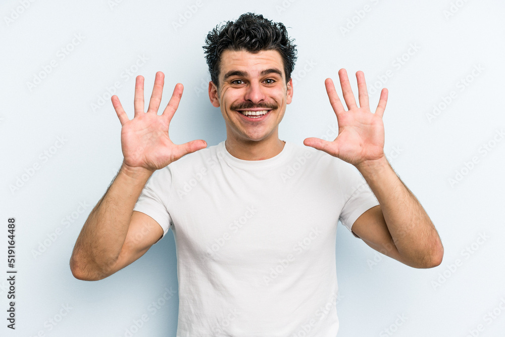 Young caucasian man isolated on blue background showing number ten with hands. Young caucasian man isolated on blue background showing number ten with hands.