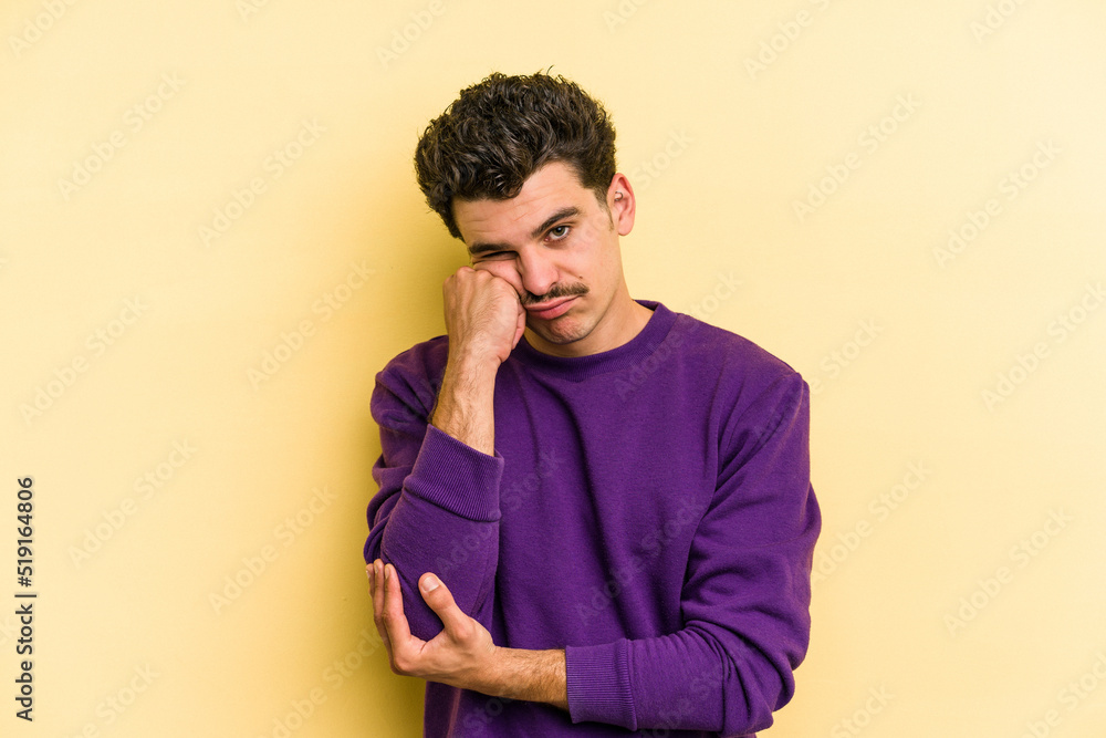 Young caucasian man isolated on yellow background who is bored, fatigued and need a relax day. Young caucasian man isolated on yellow background who is bored, fatigued and need a relax day.