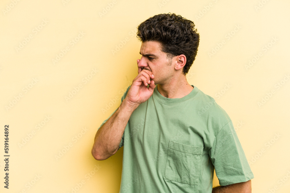 Young caucasian man isolated on yellow background keeping a secret or asking for silence. Young caucasian man isolated on yellow background keeping a secret or asking for silence.
