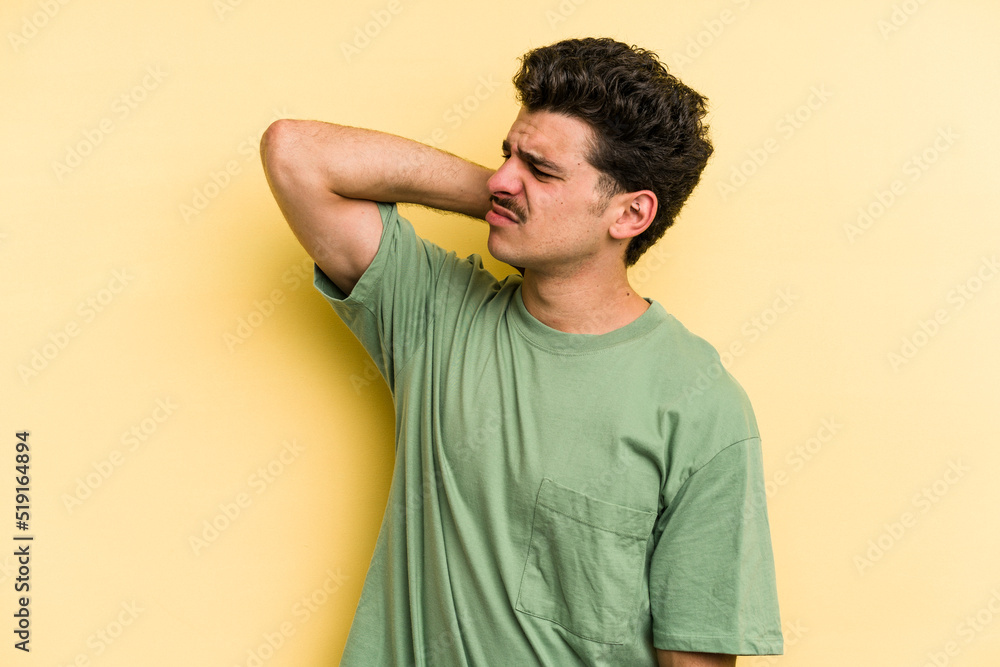 Young caucasian man isolated on yellow background tired and very sleepy keeping hand on head. Young caucasian man isolated on yellow background tired and very sleepy keeping hand on head.