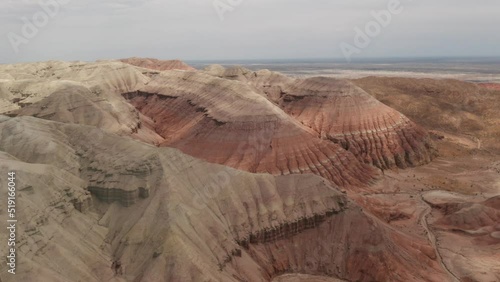 Beautiful Aktau mountains in Altyn-emel National park at bright summer day. Red mountains formed by sedimentary rocks. Aerial footage of sand rocks in a wild. photo