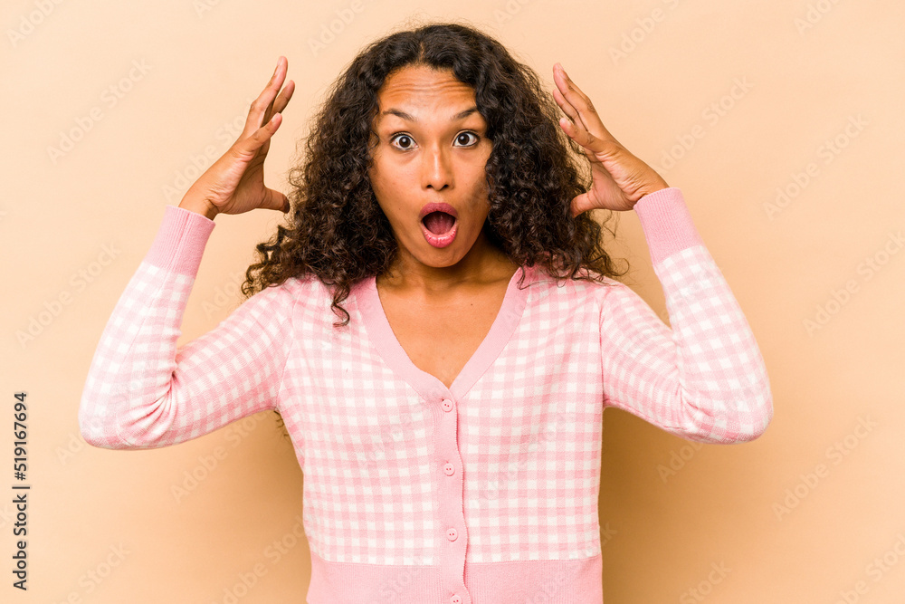 Young hispanic woman isolated on beige background celebrating a victory or success, he is surprised and shocked. Young hispanic woman isolated on beige background celebrating a victory or success, he is surprised and shocked.