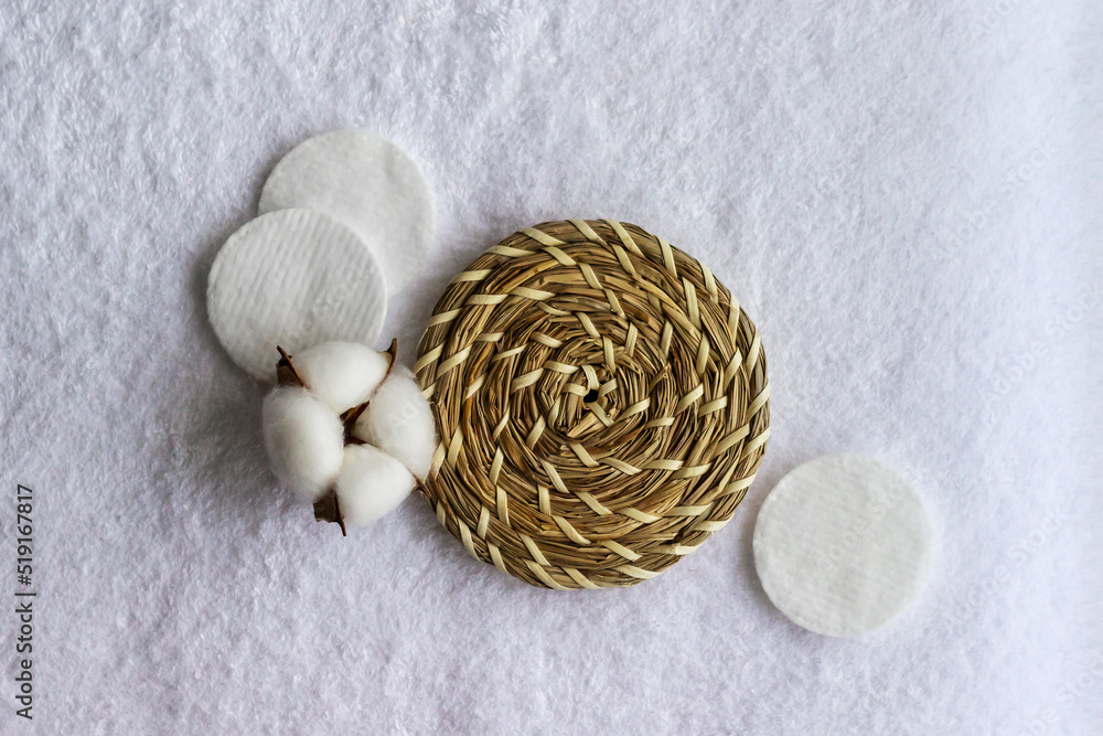 Cotton pads with cotton flower laying on the white towel