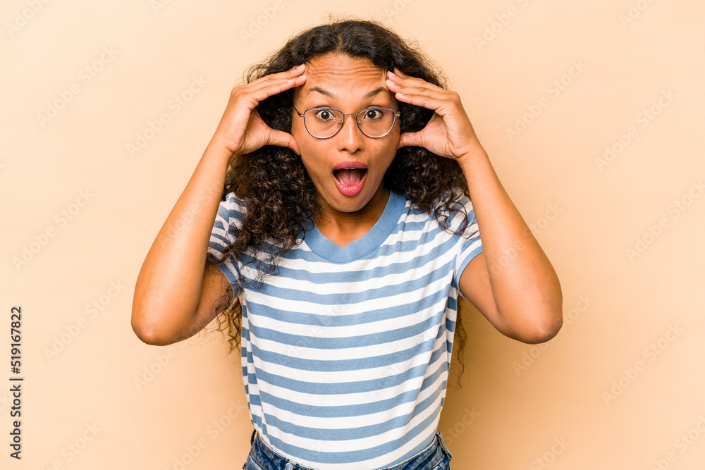 Young hispanic woman isolated on beige background receiving a pleasant surprise, excited and raising hands. Young hispanic woman isolated on beige background receiving a pleasant surprise, excited and raising hands.