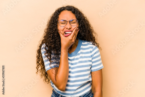 Young hispanic woman isolated on beige background having a strong teeth pain, molar ache.