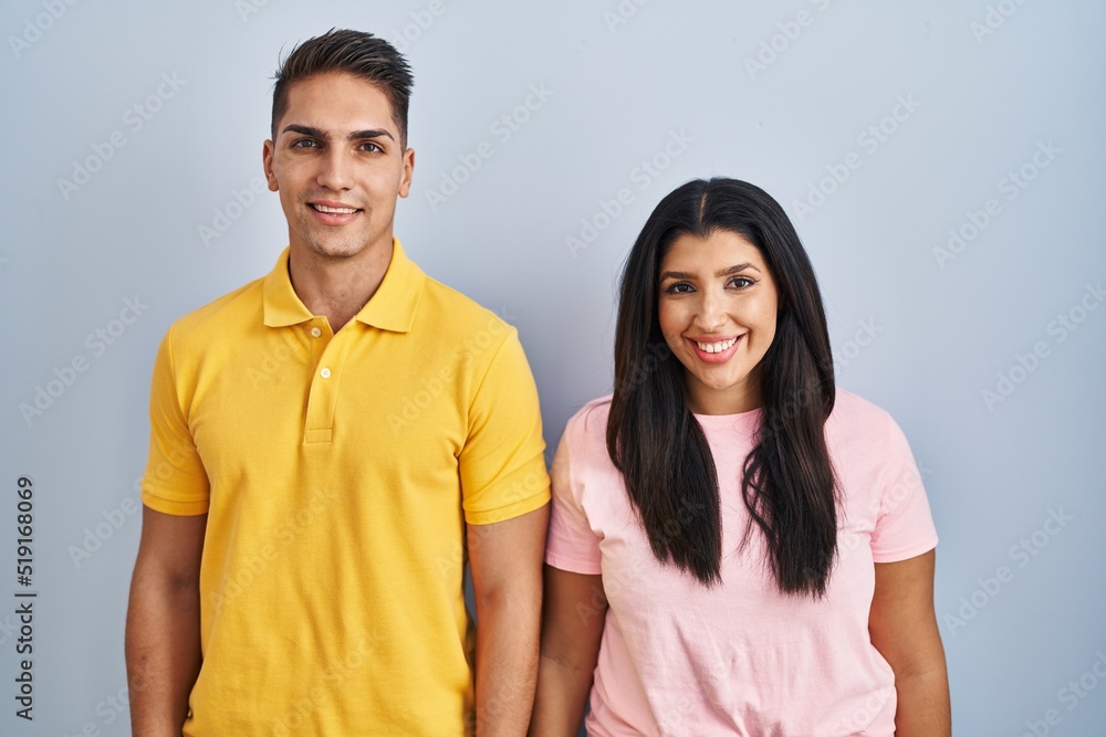 Young couple standing over isolated background with a happy and cool smile on face. lucky person.
