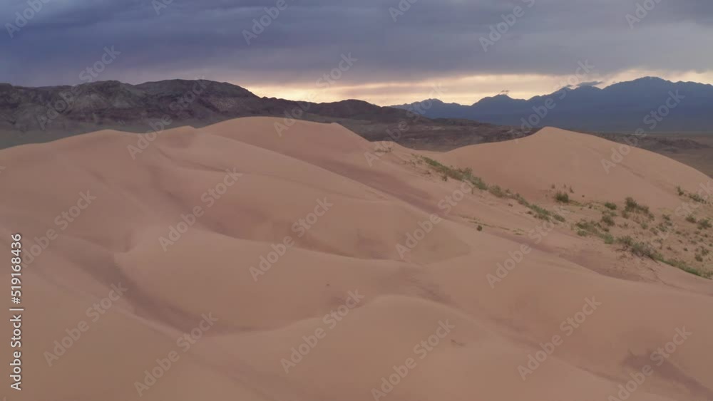 Beautiful sand dune in the wild at sunset. Aerial footage of The Singing Dune, or Aigaikum in Altyn-Emel National Park. Beautiful sand dune in the wild at sunset. Aerial footage of The Singing Dune, or Aigaikum in Altyn-Emel National Park.