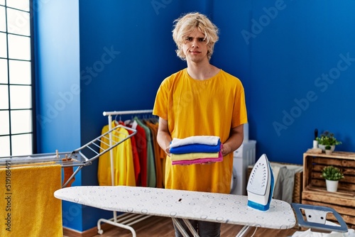 Young man ironing clothes at home skeptic and nervous, frowning upset because of problem. negative person. © Krakenimages.com