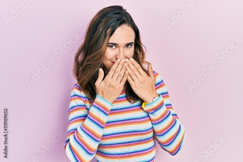 Young hispanic girl wearing casual clothes laughing and embarrassed giggle covering mouth with hands, gossip and scandal concept
