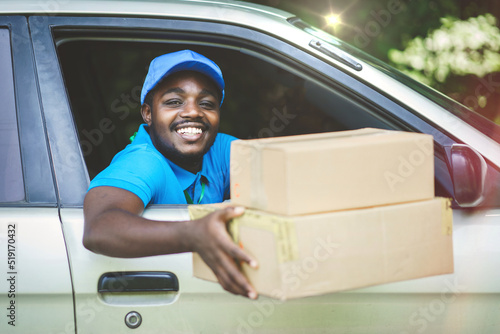 African delivery man holding a box package in the car with smile and happy.Concept of business delivery service