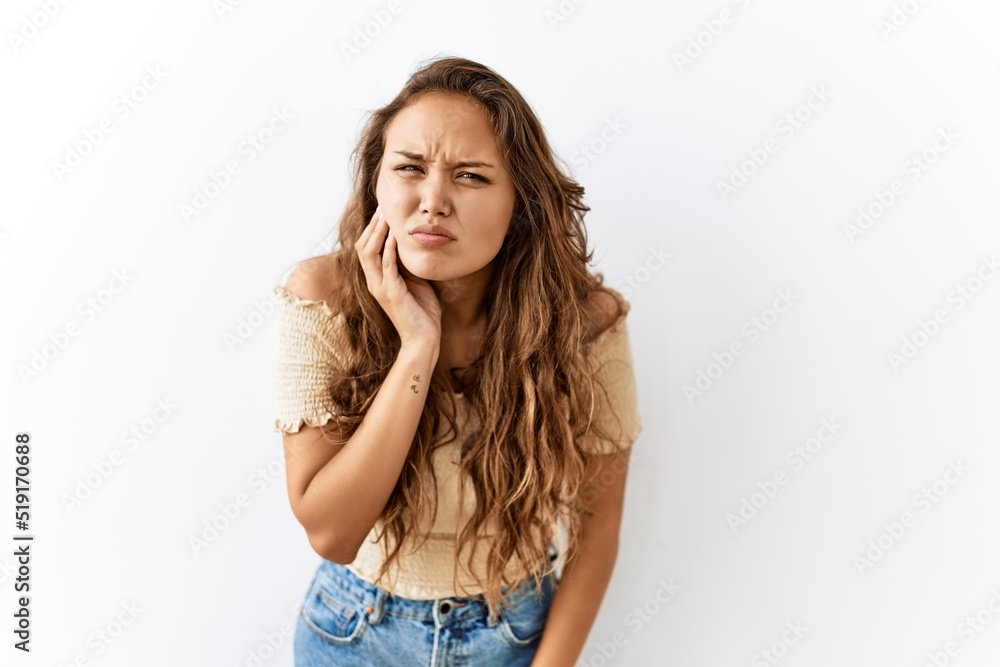 Beautiful hispanic woman standing over isolated while background touching mouth with hand with painful expression because of toothache or dental illness on teeth. dentist Beautiful hispanic woman standing over isolated while background touching mouth with hand with painful expression because of toothache or dental illness on teeth. dentist