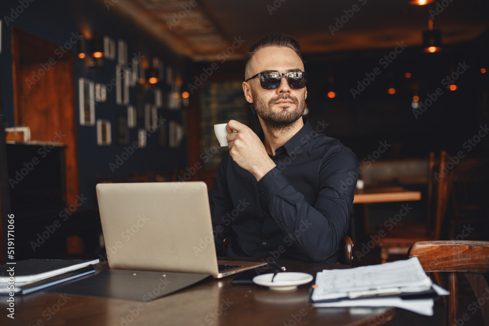 Manin glasses is sitting at the computer. Manin glasses is sitting at the computer.