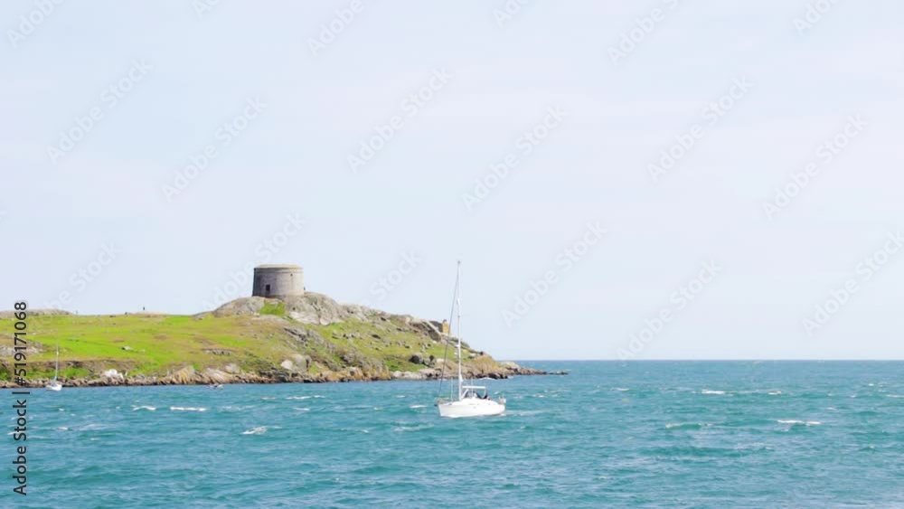 On a beautiful sunny day, Dalkey Island has a church ruin and a martello tower in the distance. Boats are slowly coming to shore. On a beautiful sunny day, Dalkey Island has a church ruin and a martello tower in the distance. Boats are slowly coming to shore.