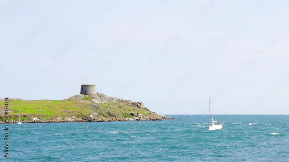 On a beautiful sunny day, Dalkey Island has a church ruin and a martello tower in the distance. Boats are slowly coming to shore. On a beautiful sunny day, Dalkey Island has a church ruin and a martello tower in the distance. Boats are slowly coming to shore.
