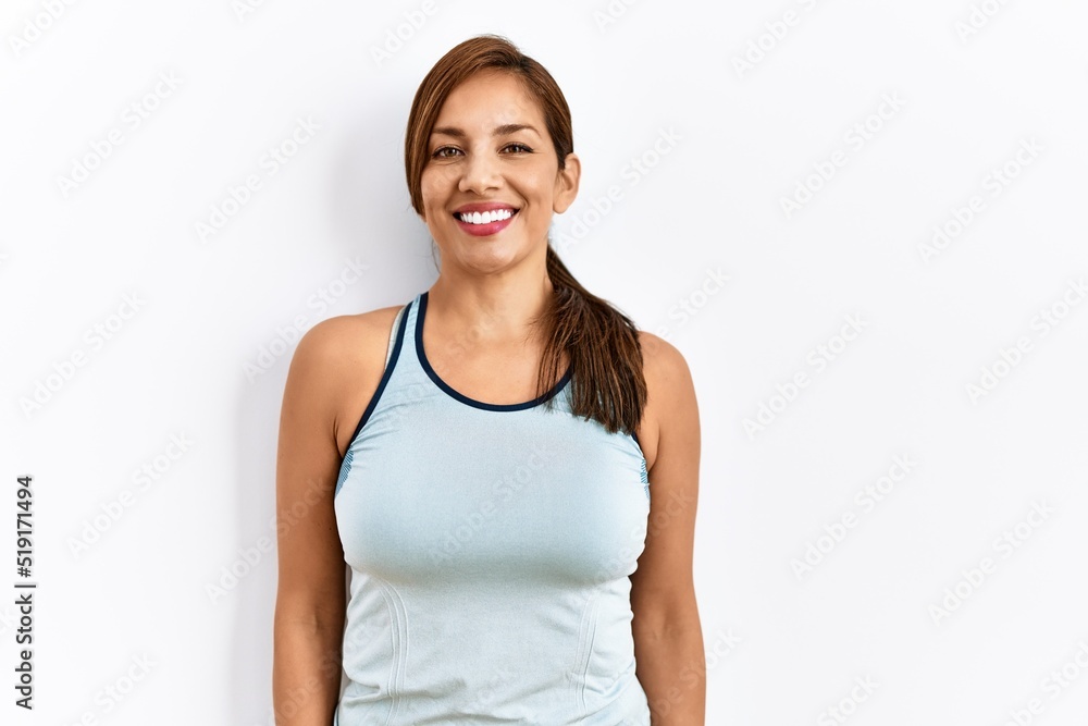 Young latin woman wearing sporty clothes over isolated background with a happy and cool smile on face. lucky person. Young latin woman wearing sporty clothes over isolated background with a happy and cool smile on face. lucky person.