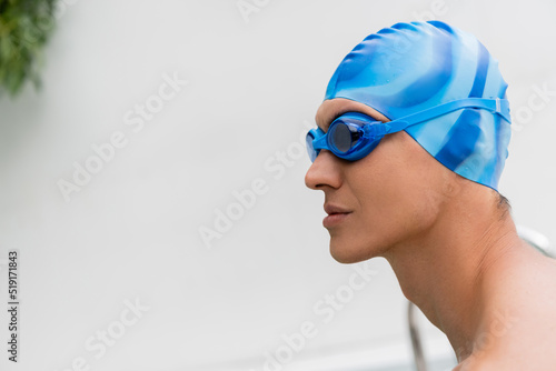 side view of man in swimming cap and goggles. photo