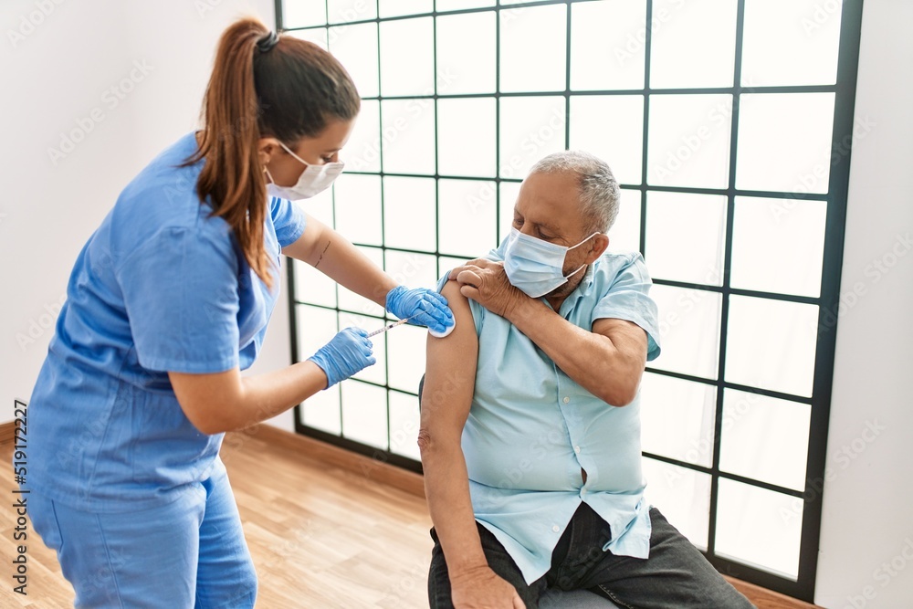 Senior man with safety mas getting vaccinated with covid 19 immunity vaccine, nurse injecting prevention vaccine Senior man with safety mas getting vaccinated with covid 19 immunity vaccine, nurse injecting prevention vaccine