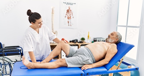 Physiotherapist and patient smiling confident having rehab session at clinic