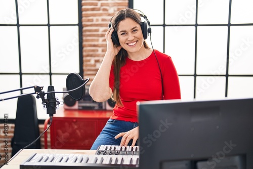 Young woman dj playing music session at music studio
