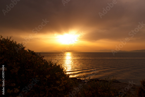 Sunset on the beach, cloudy sky in Greece, Aegean sea