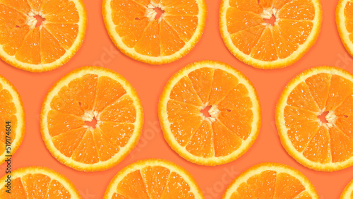 Seamless pattern with orange slices on a warm background. Fruity background, with juicy citrus pieces. Summer background