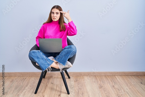 Obraz na plátne Young hispanic girl working using computer laptop shooting and killing oneself pointing hand and fingers to head like gun, suicide gesture
